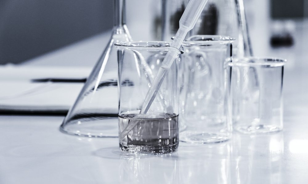 Three empty lab beakers with a pipet in one of them. Photo courtesy of Hans Reniers on Unsplash.