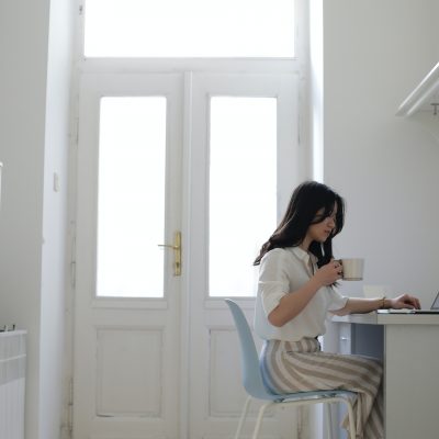 Woman sitting at a desk using her laptop. Photo courtesy of Jessica Ticozzelli on Pexels.