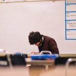 Photo of student crouched over a desk. Courtesy of Jeswin Thomas.