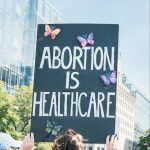 Women holding up a poster that reads "Abortion is healthcare"