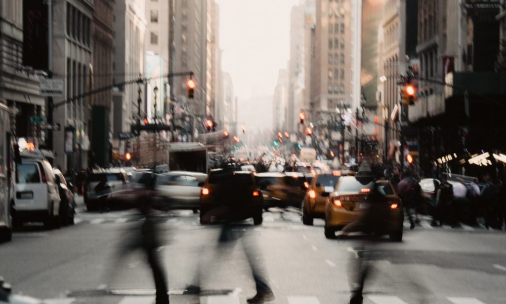 People crossing the street with cars in the background