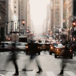People crossing the street with cars in the background