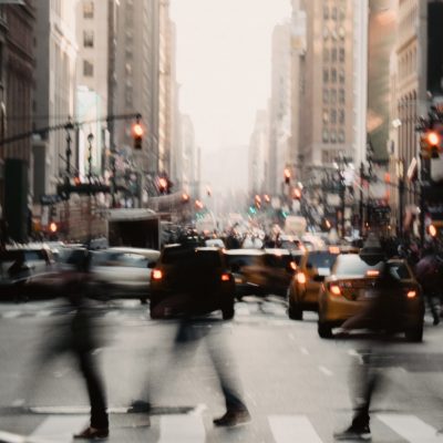 People crossing the street with cars in the background
