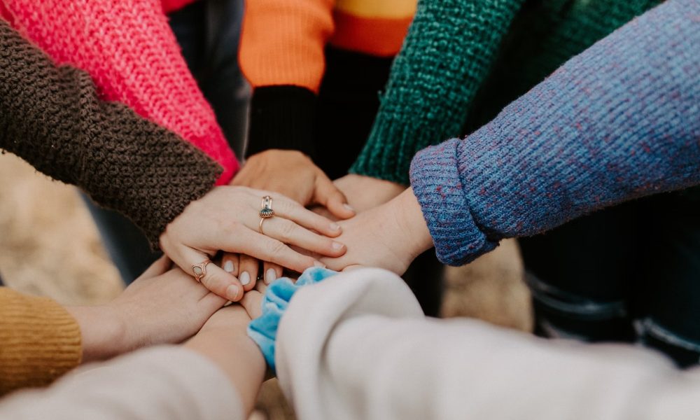 Group of people holding hands in a circle.