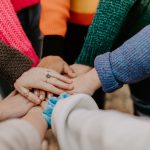 Group of people holding hands in a circle.