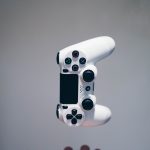 White Sony controller falling into someones hands. Photo courtesy of Nikita Kachanovsky on Unsplash.