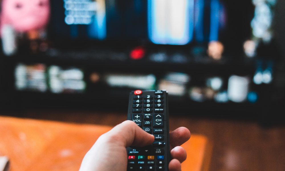Image of hand holding remote courtesy of Erik Mclean on Unsplash