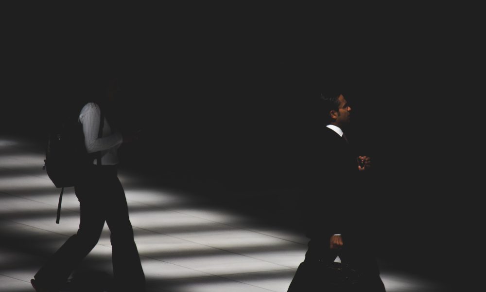 Image of two people walking in the dark.