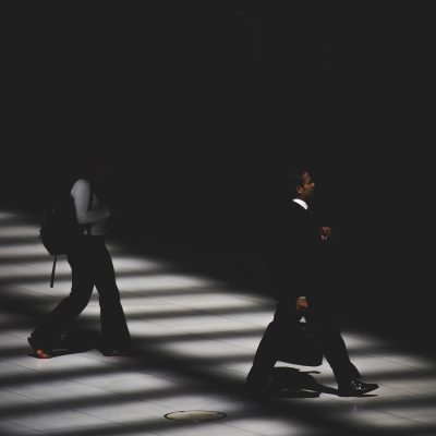 Image of two people walking in the dark.