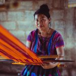 Woman working with fabric. Photo courtesy of Photo by Los Muertos on Pexels.