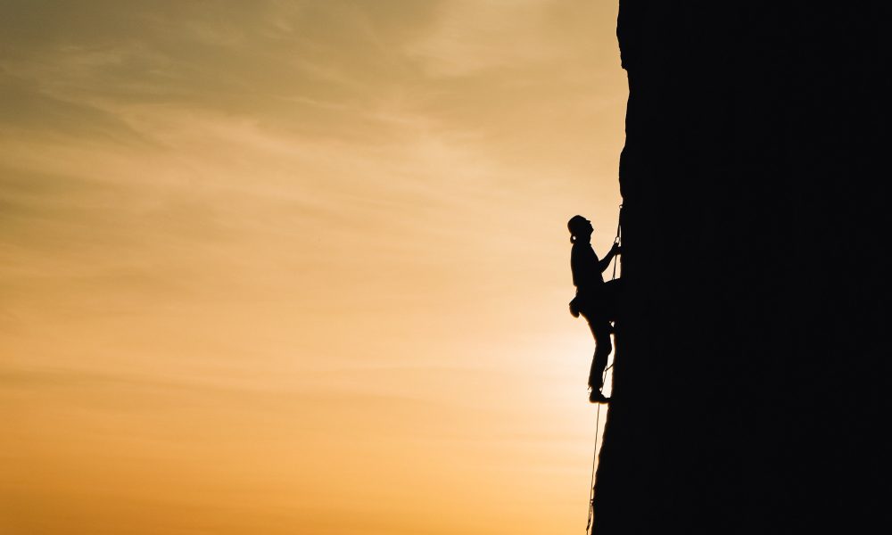 Person climbing a mountain. Photo by Анна Рыжкова on Unsplash.