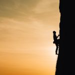 Person climbing a mountain. Photo by Анна Рыжкова on Unsplash.