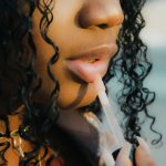 Image of girl applying lipgloss courtesy of Peter Kalonji on Unsplash