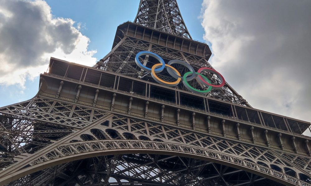 Photo of the Eiffel Tower with the Olympic logo on it. Photo courtesy of Amada MA on Unsplash.