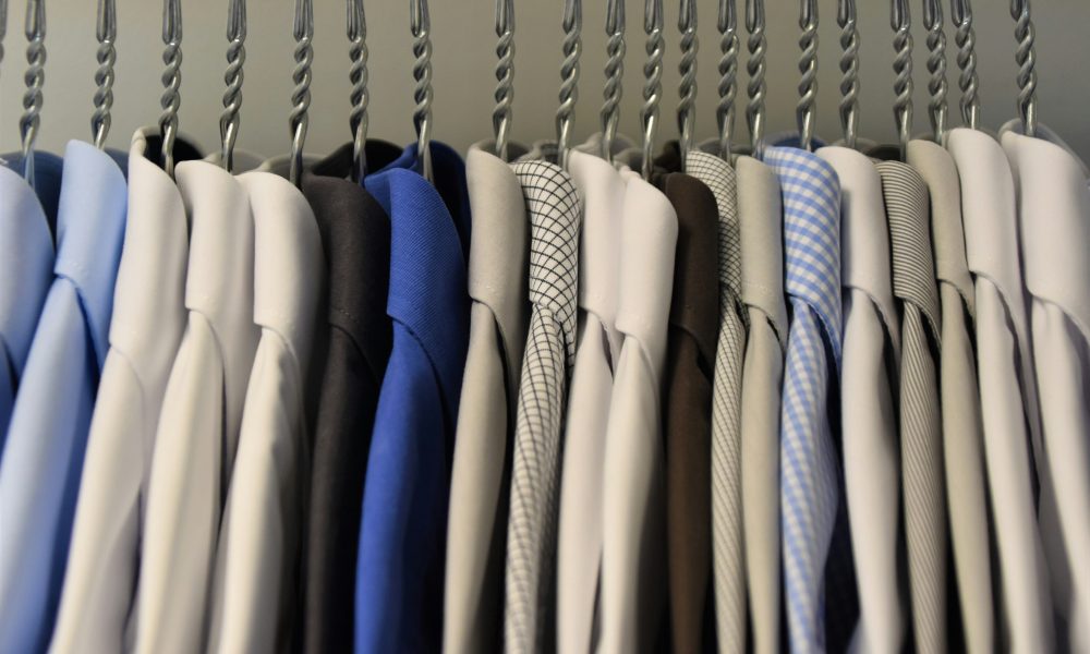 Assorted color dress shirts on clothes hangers. Photo courtesy of Waldemar on Unsplash.