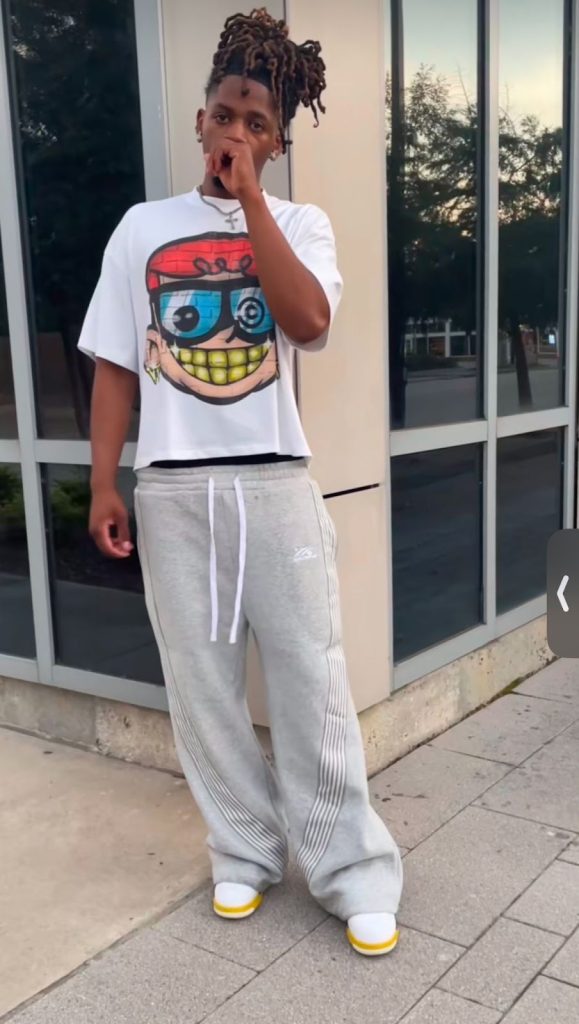 Instagram fashion post of a Black teen wearing a white hip-cropped t-shirt, grey sweatpants, and white shoes.