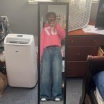 Full length mirror selfie of the author, a Black teen, wearing baggie pants and a cropped pink 70 hoodie.
