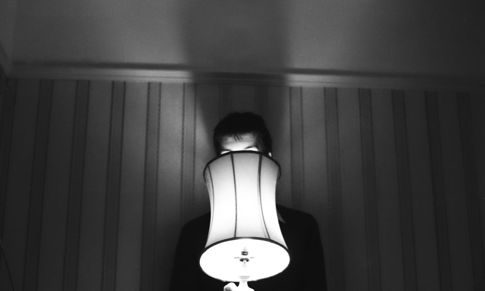 Photo of someone behind a lamp courtesy of henry perks on Unsplash.