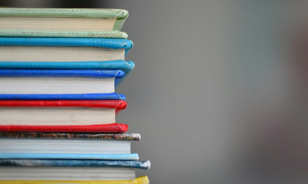 Photo of stack of books courtesy of Kimberly Farmer on Unsplash