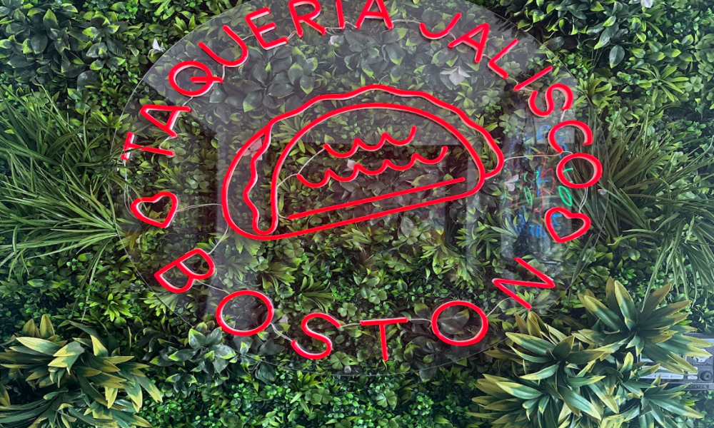 A green turf wall featuring Taqueria’s Jalisco’s logo greets customers as they walk in, setting the tone for a bold and lively dining experience.