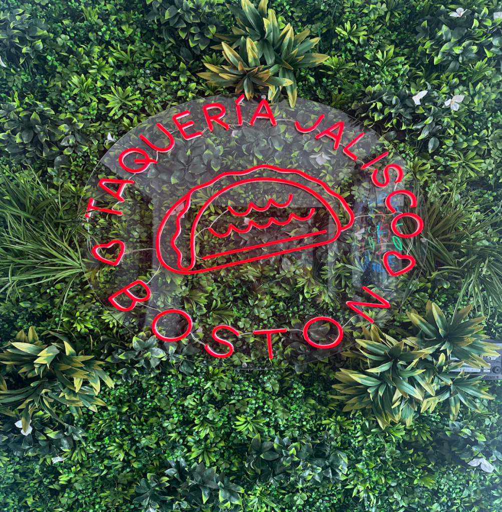 A green turf wall featuring Taqueria’s Jalisco’s logo greets customers as they walk in, setting the tone for a bold and lively dining experience.