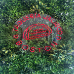 A green turf wall featuring Taqueria’s Jalisco’s logo greets customers as they walk in, setting the tone for a bold and lively dining experience.