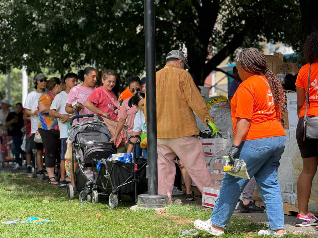 La Colaborativa volunteers handing out food and supplies at an event.