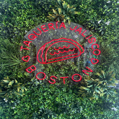 A green turf wall featuring Taqueria’s Jalisco’s logo greets customers as they walk in, setting the tone for a bold and lively dining experience.