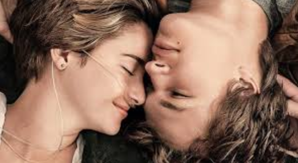 A teen girl with a nasal canula and a boy without one romantically lying with their heads close together.