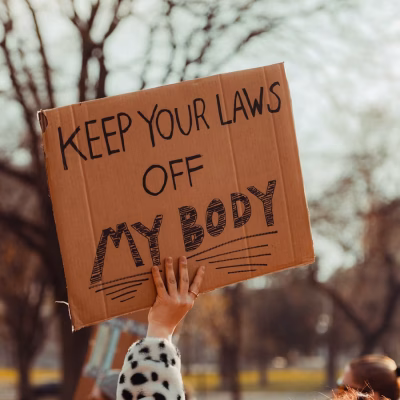 Protester holding a sign that reads Keep Your Laws Off My Body.