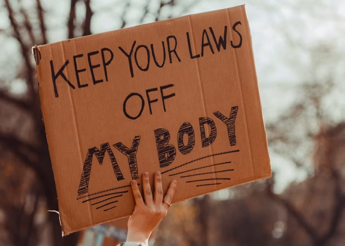 Protester holding a sign that reads Keep Your Laws Off My Body.