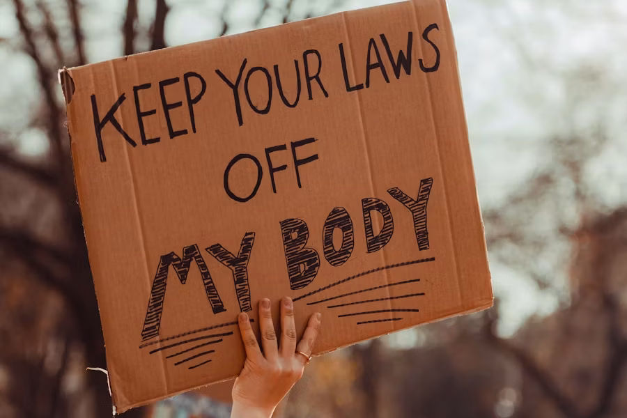 Protester holding a sign that reads Keep Your Laws Off My Body.