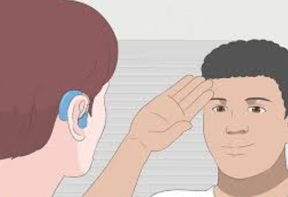 A person signs in ASL accross from someone wearing a hearing aide.