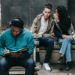 Two students whispering behind another student's back
