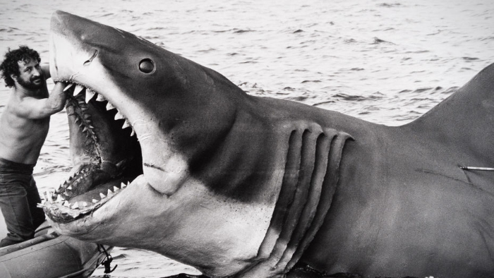 Image of the puppet shark from Jaws, with Steven Spielberg holding its mouth open