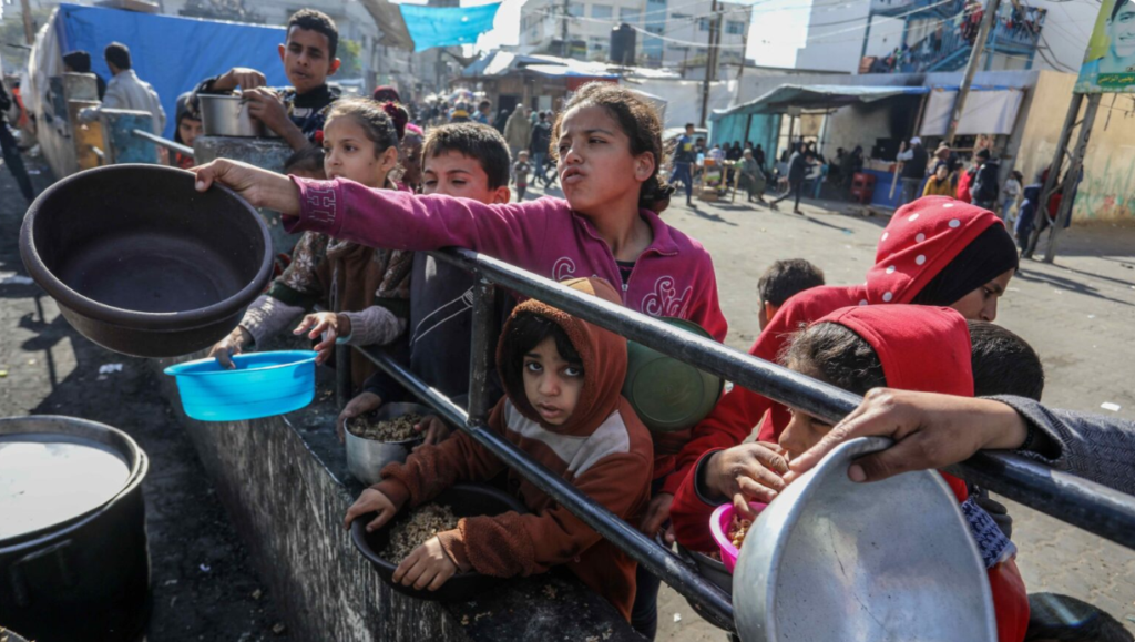A charity organization distributes food to displaced Palestinians in the Gaza Strip in February 2024.